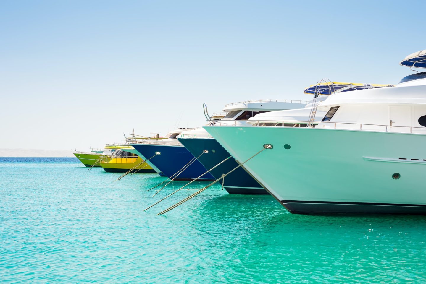 Anchored big yachts and sailboats on a turquoise water